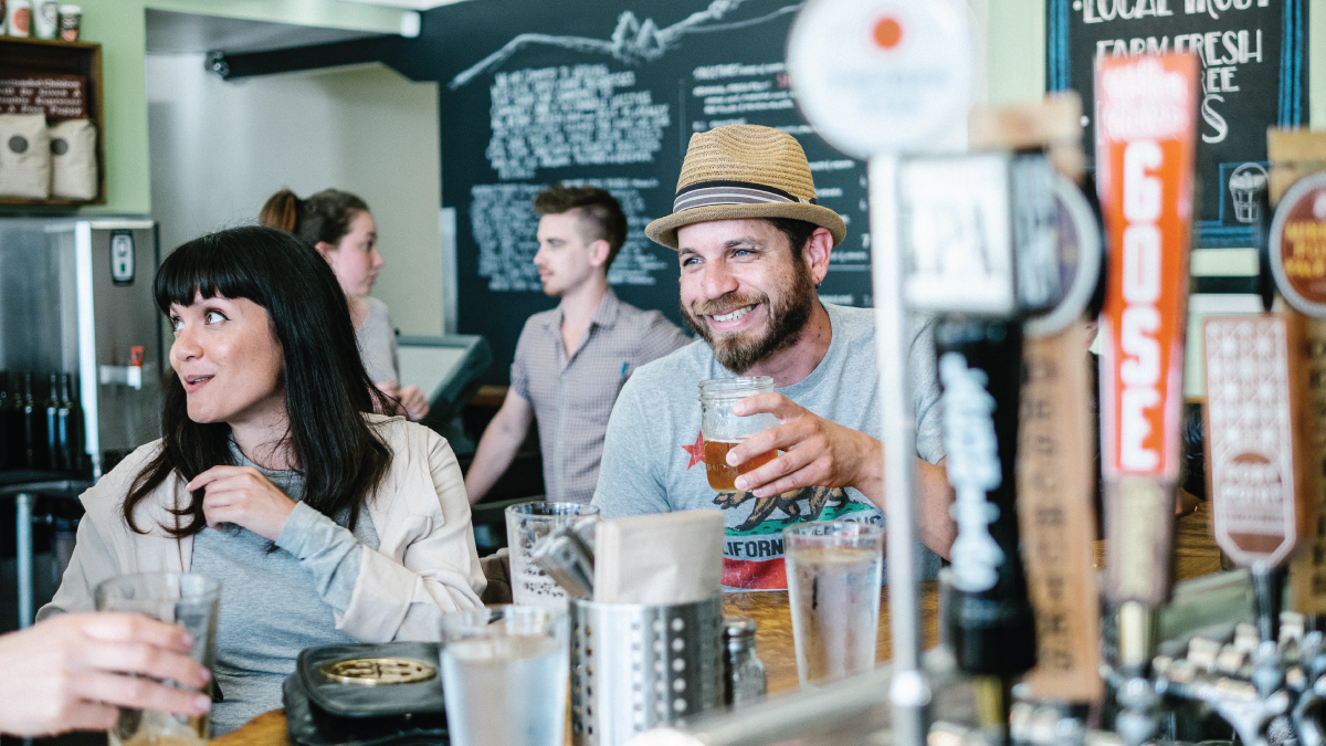 Man drinking at craft brewery while smiling